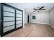 Bright bedroom with modern sliding doors, ceiling fan, light gray paint and new hardwood floors at 3165 Renatta Dr, Belleair Bluffs, FL 33770