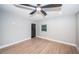 A simple bedroom featuring a ceiling fan, new floors, neutral paint and black door at 3165 Renatta Dr, Belleair Bluffs, FL 33770
