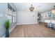 Empty dining space with hardwood floors, ample natural light, and a modern chandelier at 3165 Renatta Dr, Belleair Bluffs, FL 33770