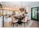 Stylish dining area with a black marble table, beige chairs, and seamless flow into living spaces at 3165 Renatta Dr, Belleair Bluffs, FL 33770