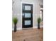 Modern entryway with sleek black door, hardwood floors, and stylish decor at 3165 Renatta Dr, Belleair Bluffs, FL 33770