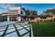 A modern home featuring a two-story design, sleek lines, a large deck, and a unique geometric driveway pattern at 3165 Renatta Dr, Belleair Bluffs, FL 33770