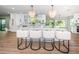Kitchen island features marble countertop, seating for four, stylish pendant lights, and white cabinets at 3165 Renatta Dr, Belleair Bluffs, FL 33770
