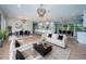 Spacious living room featuring hardwood floors, designer chandeliers, and views into the open kitchen and dining area at 3165 Renatta Dr, Belleair Bluffs, FL 33770