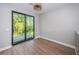 Bright room with wood flooring and large sliding doors that open to a deck, offering views of lush greenery at 3165 Renatta Dr, Belleair Bluffs, FL 33770