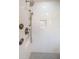 Close-up of a shower featuring stylish bronze fixtures, white herringbone tile, and a built-in soap niche at 3165 Renatta Dr, Belleair Bluffs, FL 33770