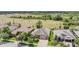 Aerial shot of a home nestled among well-maintained lawns and trees with green field in the background at 32242 Summerglade Dr, Wesley Chapel, FL 33545