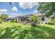 Spacious backyard with a screened-in lanai, lush green grass, and well-maintained landscaping for outdoor relaxation at 32242 Summerglade Dr, Wesley Chapel, FL 33545