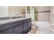 Well-lit bathroom features a double vanity with granite countertop and a shower-tub combination at 32242 Summerglade Dr, Wesley Chapel, FL 33545