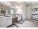 Bathroom with double vanity, soaking tub with tile surround, and glass-enclosed shower at 32242 Summerglade Dr, Wesley Chapel, FL 33545