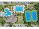 Aerial view of community amenities featuring multiple pools, a clubhouse, tennis courts, and ample parking spaces at 32242 Summerglade Dr, Wesley Chapel, FL 33545