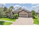 Beautiful single-story home featuring a three-car garage and lush landscaping at 32242 Summerglade Dr, Wesley Chapel, FL 33545
