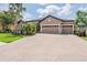 Charming home with a three-car garage, brick-paved driveway, and well-manicured landscaping, creating curb appeal at 32242 Summerglade Dr, Wesley Chapel, FL 33545