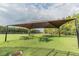 Picnic area beneath a brown awning with multiple picnic tables to enjoy outdoor dining at 32242 Summerglade Dr, Wesley Chapel, FL 33545