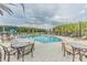 Community pool with lounge chairs, tables, and a nearby playground for relaxation and Gathering fun at 32242 Summerglade Dr, Wesley Chapel, FL 33545