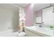 Cozy bathroom has a shower and tub with a floral shower curtain, and a vanity with a plant at 3366 Mermoor Dr # 1106, Palm Harbor, FL 34685