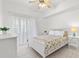 Bright bedroom featuring a ceiling fan, a bed with floral bedding, and sheer curtains at 3366 Mermoor Dr # 1106, Palm Harbor, FL 34685