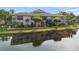 Waterfront condo building reflecting in a serene pond surrounded by lush greenery at 3366 Mermoor Dr # 1106, Palm Harbor, FL 34685