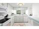 Bright, clean kitchen featuring white cabinets, modern appliances and breakfast bar at 3366 Mermoor Dr # 1106, Palm Harbor, FL 34685