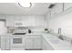 Clean kitchen featuring white cabinetry, appliances, ample counter space, and a garden window at 3366 Mermoor Dr # 1106, Palm Harbor, FL 34685