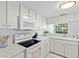Bright kitchen featuring white cabinets, modern appliances, and a pass-through window at 3366 Mermoor Dr # 1106, Palm Harbor, FL 34685