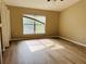 This bedroom features wood-look floors, a large window, and a ceiling fan at 3531 High Hampton Cir, Tampa, FL 33610