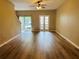 Spacious living room with wood floors, ceiling fan, and sliding glass door to backyard at 3531 High Hampton Cir, Tampa, FL 33610