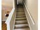 Stairway featuring wood stairs, white banisters, and views of the open-concept kitchen at 3531 High Hampton Cir, Tampa, FL 33610