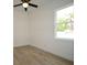 This bedroom features wood-look tile floors, a ceiling fan, and a bright window at 36755 Thomas Jefferson Rd, Dade City, FL 33525