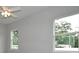Bedroom with ceiling fan and views of mature trees through bright windows at 36777 Thomas Jefferson Rd, Dade City, FL 33525