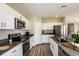 Spacious kitchen with gray countertops, stainless steel appliances, and modern cabinetry, complemented by stylish wood floors at 37122 Sagemoor Dr, Zephyrhills, FL 33541