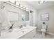 Clean bathroom features white vanity, rectangular mirror, and toilet near a shower with curtain at 3912 Doral Dr, Tampa, FL 33634