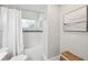 Cozy bathroom with white subway tile surround, shower curtain, and a decorative basket for storage at 3912 Doral Dr, Tampa, FL 33634