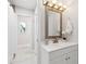 Bright bathroom featuring modern vanity, tiled floor, large mirror and decorative flower arrangement at 3912 Doral Dr, Tampa, FL 33634