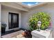 Covered front porch featuring a black door, brickwork, a Welcome mat, a decorative lamp and shrubbery at 3912 Doral Dr, Tampa, FL 33634