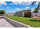 Well-maintained front yard with healthy green grass, white wall, and vibrant flowering bushes at 3912 Doral Dr, Tampa, FL 33634
