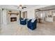 Cozy living room with a stone fireplace, plush blue chairs, and open view to kitchen and dining area at 3912 Doral Dr, Tampa, FL 33634
