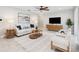 Bright living room featuring a white couch, ceiling fan, light walls, and a decorative area rug at 3912 Doral Dr, Tampa, FL 33634