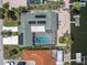Aerial view of a home with a screened pool, solar panels, patio and private dock on a canal at 4055 Floramar Ter, New Port Richey, FL 34652