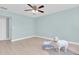 Bright bedroom features laminate floors, a ceiling fan, neutral walls, and baseboards at 4055 Floramar Ter, New Port Richey, FL 34652
