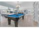 Bright game room features a pool table, tile floors, and an open layout that connects to the kitchen and dining areas at 4055 Floramar Ter, New Port Richey, FL 34652