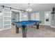 Spacious game room with pool table, barn door, bright lighting, and office access at 4055 Floramar Ter, New Port Richey, FL 34652