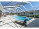 Enclosed pool with clear roof, lounge chair, and patio with outdoor furniture at 4055 Floramar Ter, New Port Richey, FL 34652