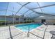 Enclosed pool with a clear-roofed enclosure and paved deck area for outdoor seating at 4055 Floramar Ter, New Port Richey, FL 34652