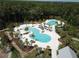 Aerial view of community pool featuring multiple pools, lounge chairs and mature landscaping at 4093 Epic Cv, Land O Lakes, FL 34638