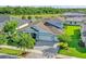 Stunning aerial view of home with lake view, lush landscaping, and brick paver driveway at 4093 Epic Cv, Land O Lakes, FL 34638