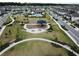 Aerial view of park featuring a playground, pool, and seating area surrounded by houses at 4093 Epic Cv, Land O Lakes, FL 34638
