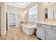 Bright bathroom with a standalone tub, double vanity, and wood-look flooring, creating a spa-like retreat at 4093 Epic Cv, Land O Lakes, FL 34638