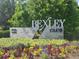 Welcoming 'Bexley Club' entrance with vibrant flowerbeds and lush greenery, creating an inviting community gateway at 4093 Epic Cv, Land O Lakes, FL 34638