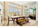 Bright dining room featuring a large wooden table with bench seating and large windows with plantation shutters at 4093 Epic Cv, Land O Lakes, FL 34638